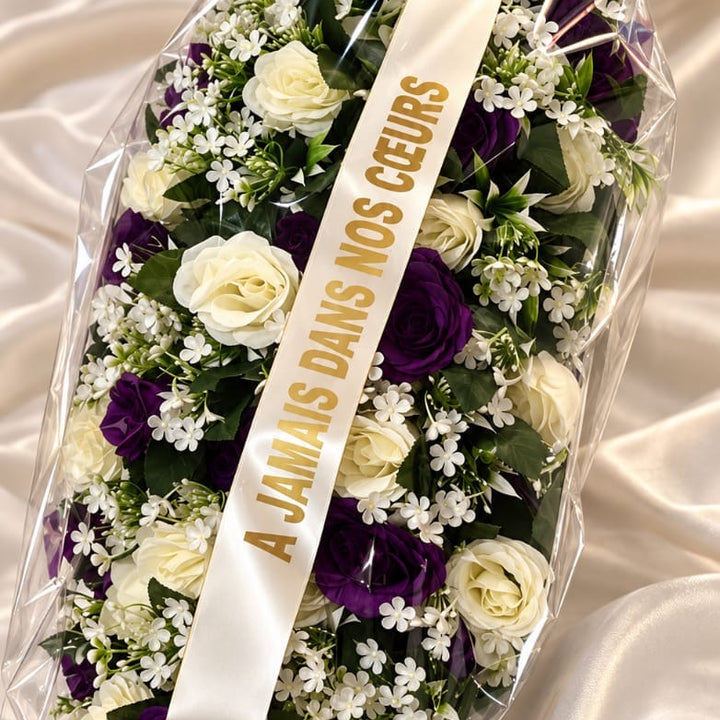Gerbe longue de roses violettes et blanches, ruban « À jamais dans nos cœurs »